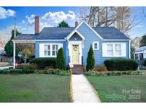 Charming blue home with a brick chimney, manicured lawn, and a welcoming yellow front door at 968 Waverly Ave, Rock Hill, SC 29730