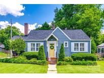Charming blue home featuring a bright yellow door with a wreath and well-manicured lawn and landscaping at 968 Waverly Ave, Rock Hill, SC 29730