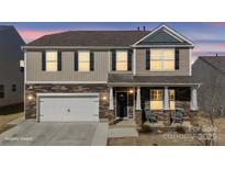 Charming two-story home featuring a stone facade, inviting porch, and attached two-car garage at 127 Giant Oak Ave, Statesville, NC 28677