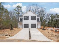 Modern, white two-story home featuring a double garage and a long, concrete driveway at 2811 New Pineola Rd, Charlotte, NC 28208