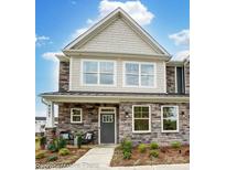 Charming two-story home with stone accents, covered porch, and manicured landscaping creates curb appeal at 4230 Black Ct # 235, Harrisburg, NC 28075