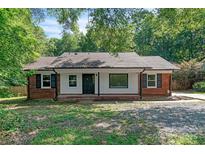 Charming single-story home with brick accents, black shutters, and fresh exterior paint at 711 E John St, Matthews, NC 28105