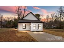 Charming exterior of a modern home featuring black trim, white siding, and fresh landscaping at 923 Cedar St, Salisbury, NC 28144