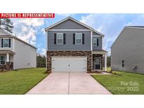 Two-story home showcasing stone accents, gray siding, a two-car garage, and a well-manicured lawn at 11204 Cardinal Creek Ave, Charlotte, NC 28215