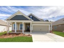 Charming single-Gathering home featuring a welcoming front porch, stone accents, and a two-car garage at 121 Noah Ln, Troutman, NC 28166