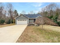Charming home featuring a combination of stone and vinyl siding, complemented by an attached two-car garage and a well-manicured lawn at 121 Purple Finch Ln, Mooresville, NC 28117