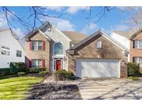Charming two-story home with brick accents, red shutters, and a well-manicured lawn at 16207 Hollingbourne Rd, Huntersville, NC 28078