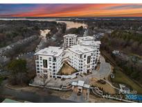 Luxury condo complex showcasing modern architecture, lush landscaping, and waterfront views at sunset at 19329 Watermark Dr # 551/552, Cornelius, NC 28031