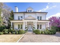 Elegant white brick home with a manicured front yard and charming covered porch at 2109 Wellesley Ave, Charlotte, NC 28207
