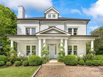 Charming brick home with white pillars, manicured landscaping and covered front porch at 2109 Wellesley Ave, Charlotte, NC 28207