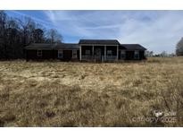 Overgrown front yard and a single-story house with a porch needing some TLC at 471 Shinnville Rd, Mooresville, NC 28115