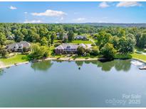 Expansive lakefront estate with lush greenery providing privacy and scenic views, perfect for luxurious living at 6823 Manatee Dr, Concord, NC 28025