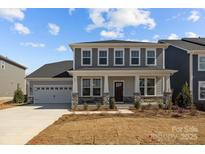 Charming two-story home with a welcoming front porch and gray siding under a blue sky at 845 Regulus Ct, York, SC 29745
