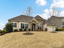 Charming ranch-style home featuring a stone-accented entrance, manicured lawn, and attached two-car garage at 10094 Dressage Ln, Midland, NC 28107