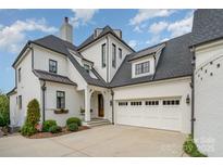 Stunning two-story home with a three-car garage, beautiful landscaping, and a classic white brick exterior at 1328 S Kings Dr, Charlotte, NC 28207