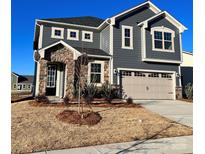 Charming two-story home with stone facade, gray siding, and attached two-car garage at 1463 Honey Trl, Monroe, NC 28112