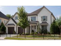 Beautiful white brick home featuring a meticulously landscaped front yard and a convenient two-car garage at 2016 Thatcher Way, Fort Mill, SC 29715