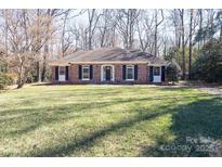 Charming brick home with dark shutters and manicured lawn surrounded by mature trees at 4501 Pine Valley Rd, Charlotte, NC 28210