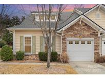 Charming home featuring a stone facade, white garage door, and nicely manicured landscaping at 526 Pine Links Dr, Tega Cay, SC 29708