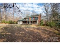 Charming two-story brick home with a welcoming front porch and well-manicured lawn at 7210 Timber Ridge Dr, Mint Hill, NC 28227