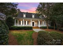Charming home with a welcoming front porch, manicured lawn, and a beautiful sunset backdrop at 103 Patience Place Ln, Mooresville, NC 28117