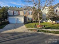 Charming two-story home featuring a two-car garage, a well-manicured lawn, and classic architecture at 10415 Plantain Ct, Charlotte, NC 28213