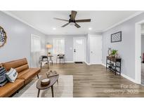 Bright living room featuring light gray walls, modern fan, and wood-look floors at 1075 Wellman St, Gastonia, NC 28054