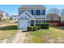 Charming two-story home with light blue siding, black shutters, a well-manicured lawn, and a single-car garage at 11843 Kearney Ct, Charlotte, NC 28273