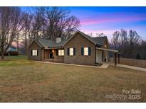 Charming brick home with a covered carport and inviting front porch, set on a spacious lawn at 4065 Lost Creek Ct, Hickory, NC 28602