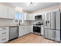 Modern kitchen featuring stainless steel appliances, white cabinetry, and light countertops at 4065 Lost Creek Ct, Hickory, NC 28602