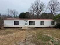 Modest single-story home with a red roof and horizontal white siding on an overcast day at 4161 Slanting Bridge Rd, Sherrills Ford, NC 28673