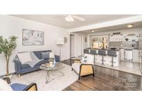 Bright and airy living room featuring hardwood floors, stylish furniture, and an open layout to the kitchen at 4930 Crestmont Dr, Charlotte, NC 28205