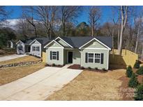 Charming single-story home with a well-manicured front yard and a concrete driveway at 916 Moose St, Lowell, NC 28098