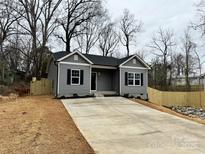 Charming single-story home with a well-manicured front yard and a long driveway at 920 Moose St, Lowell, NC 28098