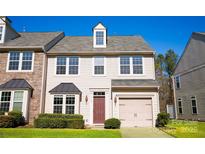 Charming two-story townhome with beige siding, attached garage, and well-maintained front lawn at 9760 Springholm Dr, Charlotte, NC 28278