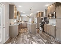 Bright, modern kitchen with stainless steel appliances, island, and ample counter space for cooking at 1005 Maywood St, Kannapolis, NC 28081