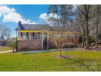 Charming brick home with a covered front porch and well-maintained lawn at 126 Lynnwood Ln, Pineville, NC 28134