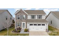 Charming two-story home with stone accents, a two-car garage, and meticulously landscaped front yard at 1535 Scarbrough Sw Cir, Concord, NC 28025