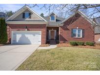 Charming red brick home with a well-manicured lawn, a two-car garage, and classic architectural details at 4008 Saint Andrews Ct, Cramerton, NC 28032