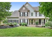 Charming two-story home with stone accents, a welcoming porch, and a beautifully landscaped front yard at 7191 Grist Mill Ct, Denver, NC 28037