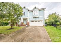 Charming two-story home with light-blue siding, a front porch and manicured front lawn at 8008 Breckenhill Ln, Tega Cay, SC 29708