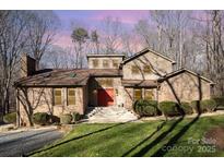Charming home with a brick exterior, complemented by manicured landscaping and mature trees at 1006 Lost Cv, Weddington, NC 28104