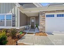 Charming front porch with stone accents, bench, and welcoming decor at 1332 Augustus Beamon Dr, Indian Trail, NC 28079