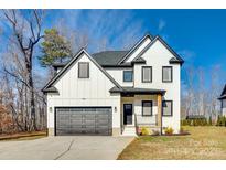 Beautiful two-story home with white brick, black trim, and a two-car garage at 2143 Country Club Rd, Lincolnton, NC 28092