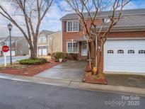 Charming brick townhome with a single car garage and well-maintained landscaping at 2424 Oak Hill Village Ln, Charlotte, NC 28217