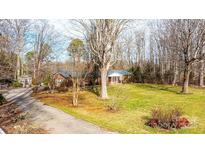 Charming one-story brick home with a well-manicured lawn and mature trees at 6000 George Hildebran School Rd, Hickory, NC 28602