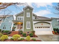 Charming two-story home featuring a well-manicured lawn, inviting front porch, and attached two-car garage at 7541 Thorn Creek Ln, Tega Cay, SC 29708
