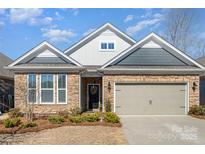 Charming single-Gathering home showcasing stone accents, well-manicured landscaping, and a welcoming two-car garage at 810 Latrobe Dr, Iron Station, NC 28080
