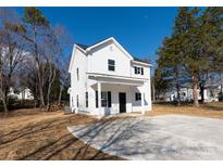 Charming two-story home with white siding, black door and windows, and a covered front porch at 8705 Moody Rd, Charlotte, NC 28215
