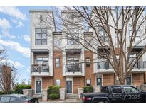Modern townhome exterior with brick and light-colored siding, balconies, and professional landscaping at 946 E 8Th St, Charlotte, NC 28204